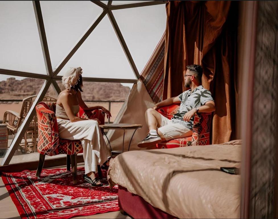 a group of people sitting in chairs in a tent at Omar wadi rum camp in Wadi Rum