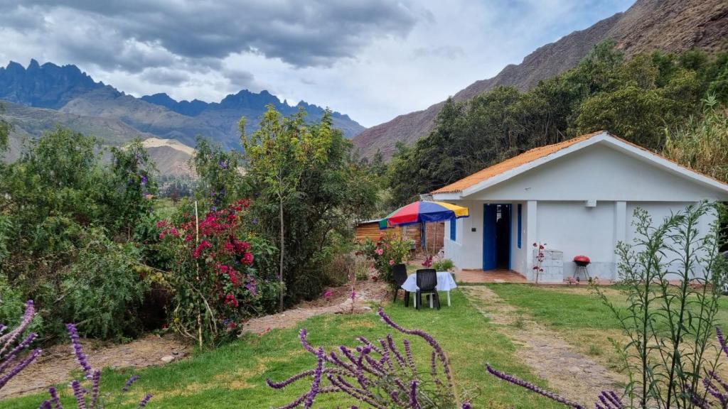 HuayllabambaRelaxing small cottage in nature的一座白色的小房子,后面是群山