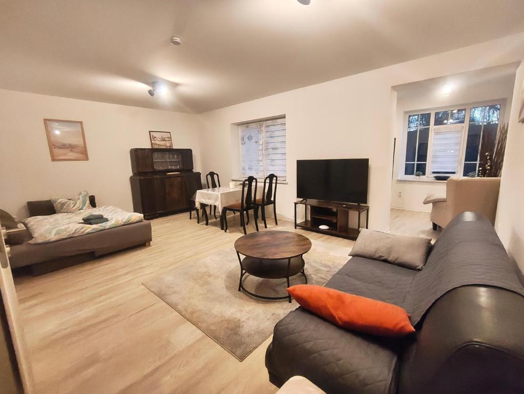uma sala de estar com um sofá e uma mesa em Ferienapartment am Dorfteich em Trebbin