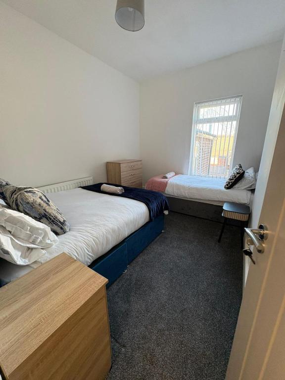 a bedroom with two beds and a window at Spacious 3-Bedroom Apartment with Modern Comforts in Runcorn