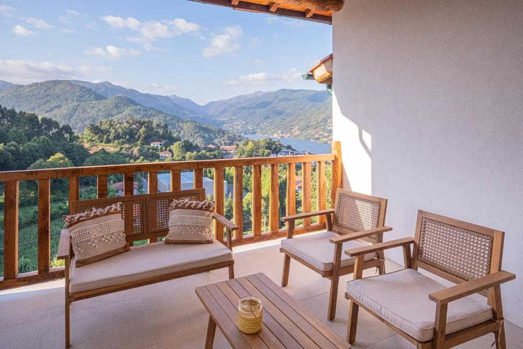 a balcony with chairs and a table and a view at Casas de São Pedro in Geres