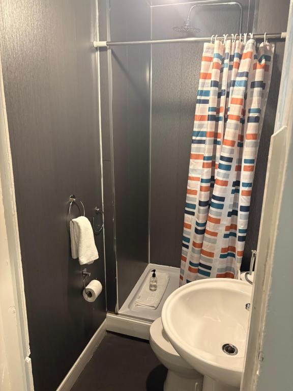 Un baño con ducha, inodoro y lavabo. en Segreto Inn, en Glasgow