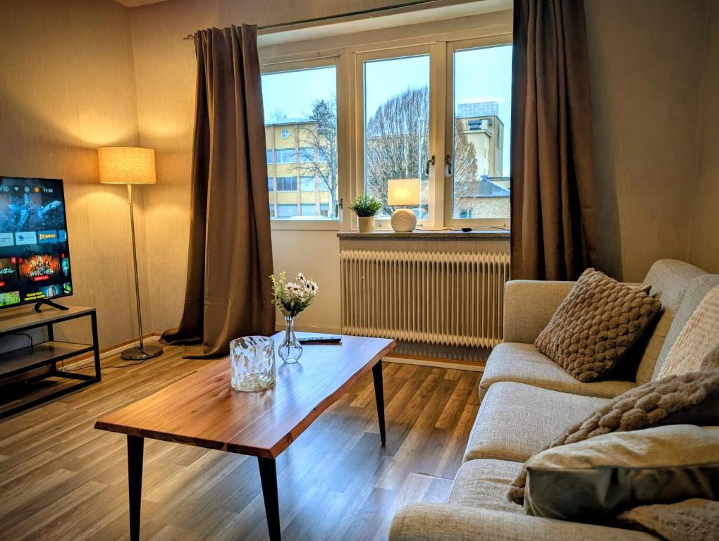 a living room with a couch and a coffee table at Cosy & modern 3-sleeps apartment near Katrineholm Centre in Katrineholm
