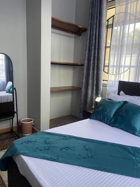 a bedroom with a bed with blue pillows and a window at Famurest in Nkoanrua