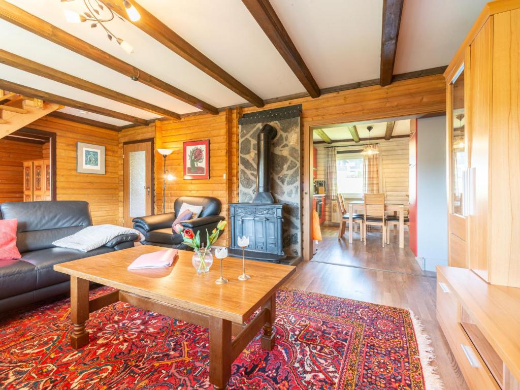 a living room with a table and a fireplace at Apartment Am Hohen Bogen-64 by Interhome in Kummersdorf