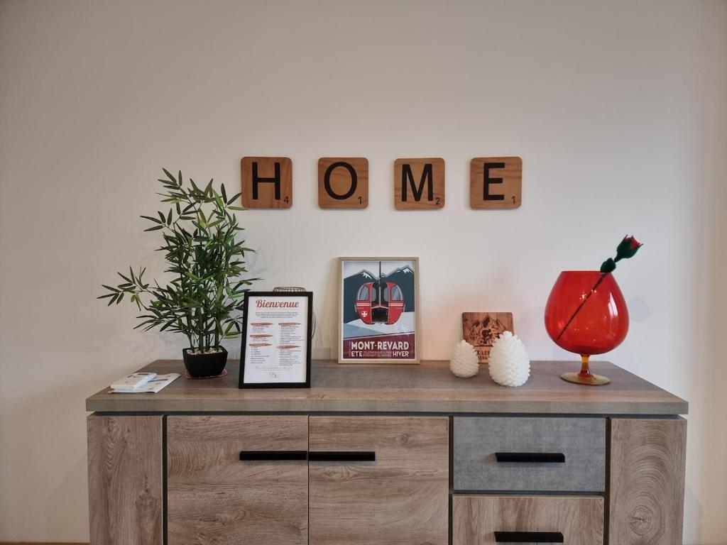 une commode en bois avec un panneau « maison » sur le mur dans l'établissement MALIBAIX, à Aix-les-Bains