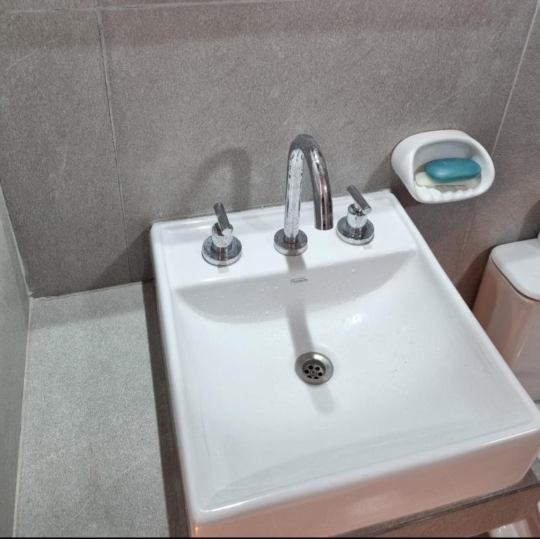 ein weißes Waschbecken im Bad neben einem WC in der Unterkunft Apart Altos de Monte Hermoso in Monte Hermoso