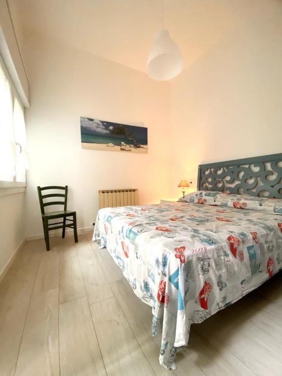 a bedroom with a bed and a chair at DolceMare - Apartment in Lido di Jesolo