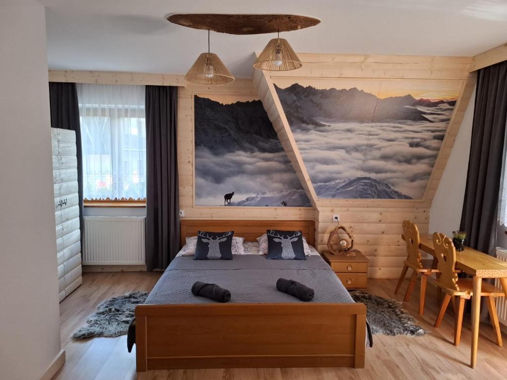 a bedroom with a bed and a painting on the wall at Pokoje gościnne Małgorzata i Piotr Bobek in Zakopane