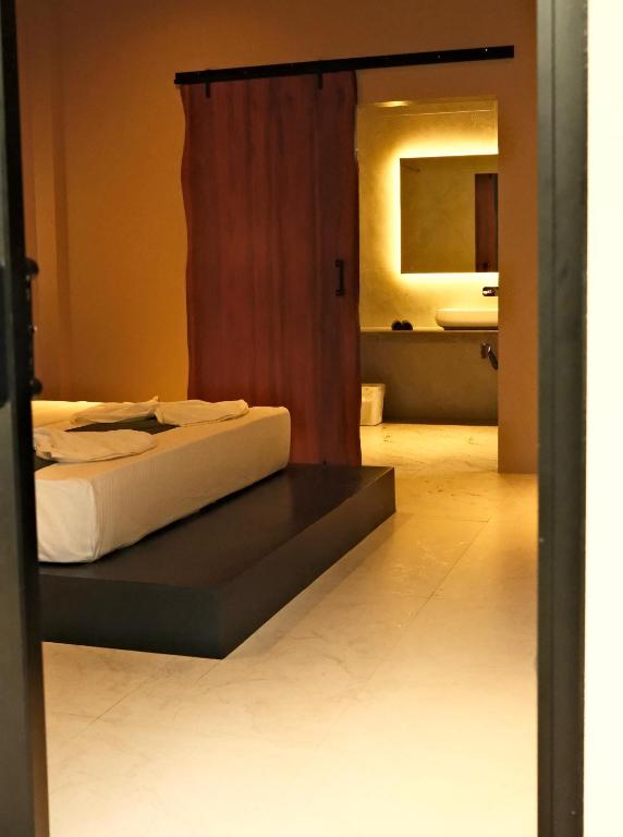 a bedroom with a bed and a bathroom with a mirror at Serenity Villa in Dickwella