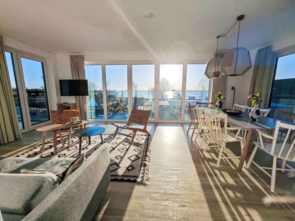 a living room with a couch and a table and chairs at Apartment Penthouse Seeblick by Interhome in Lembruch