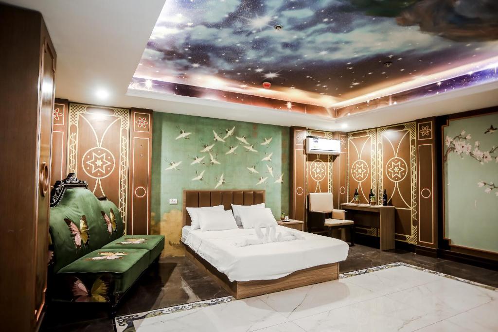 SampongにあるUnderskies Spa and Hotelのベッドと宇宙の絵が飾られた寝室