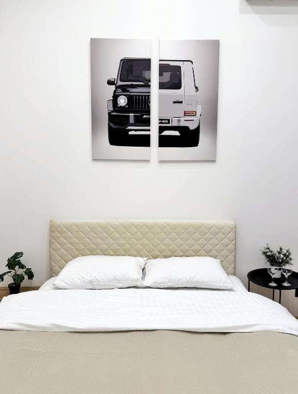 a bedroom with a bed with a picture of a white van at Kyiv Gelik Apartment in Kyiv