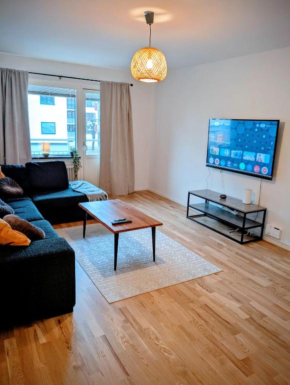 een woonkamer met een bank en een salontafel bij All you need! Fully furnished apartment in the heart of Katrineholm in Katrineholm