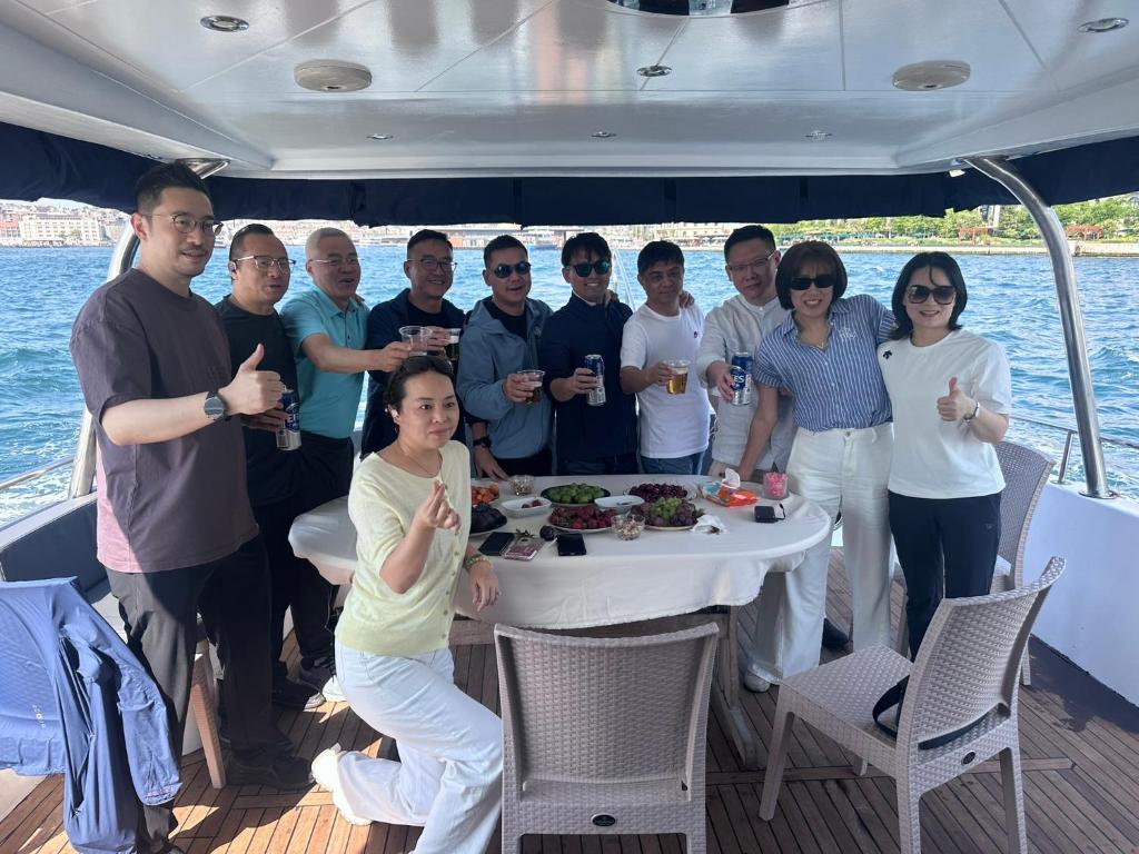 eine Gruppe von Menschen, die um einen Tisch auf einem Boot stehen in der Unterkunft Private Luxury Bosphorus Yacht 2 Continents Experience in Istanbul