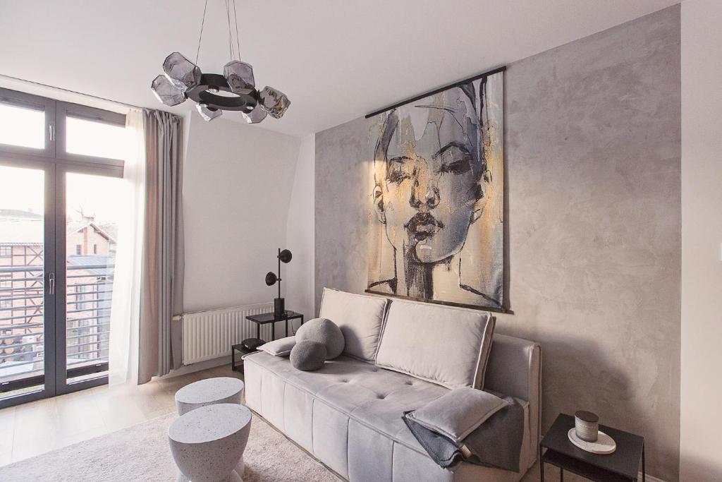 a living room with a couch and a painting on the wall at Urban Nest in Szczecinek