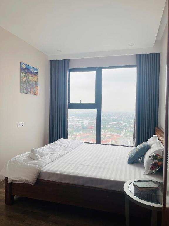 a bed in a room with a large window at Nana Home in Kim Quan