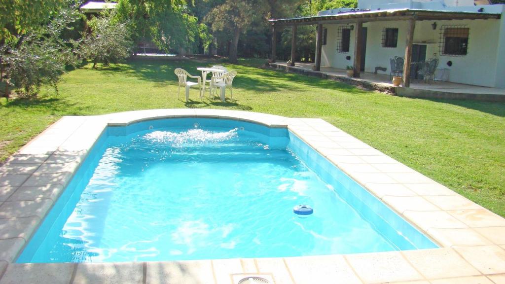 a swimming pool in a yard with a house at Las Glicinas de Chacras in Chacras de Coria