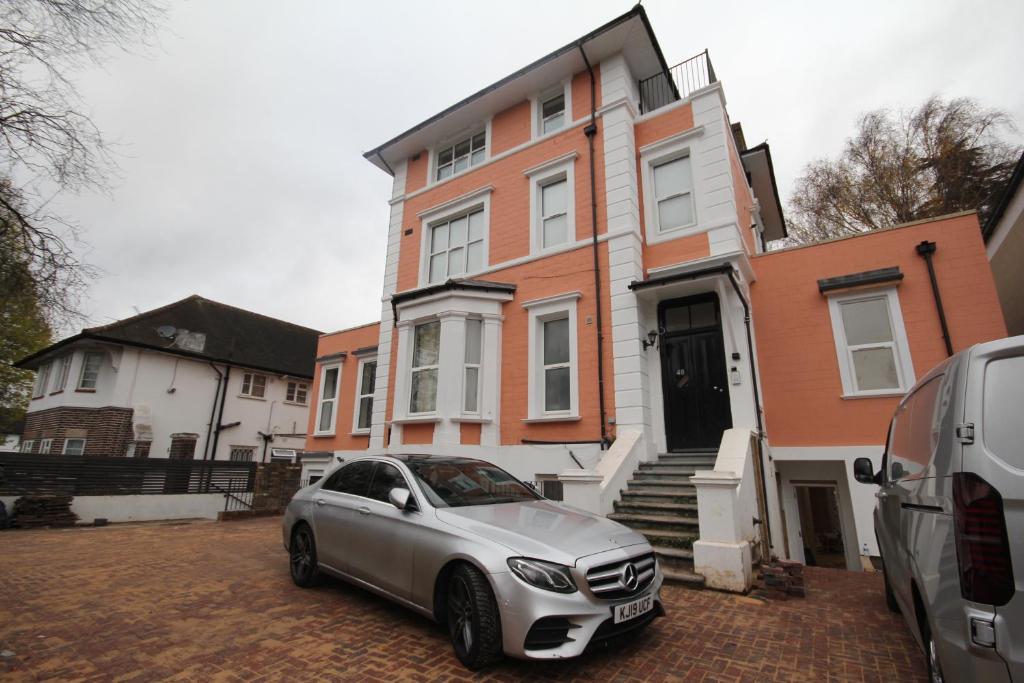 une voiture en argent garée devant une maison dans l'établissement Isleworth Place - Apt D, à Hounslow