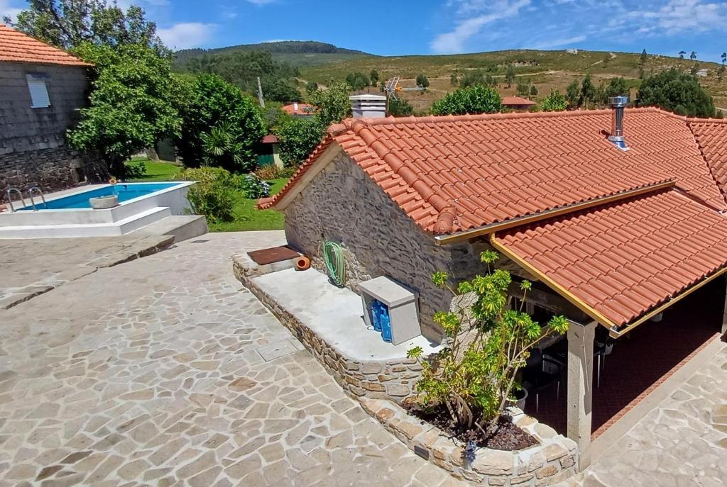 una casa con tetto piastrellato e piscina di Casa da Rosa Porreiras a Paredes de Coura
