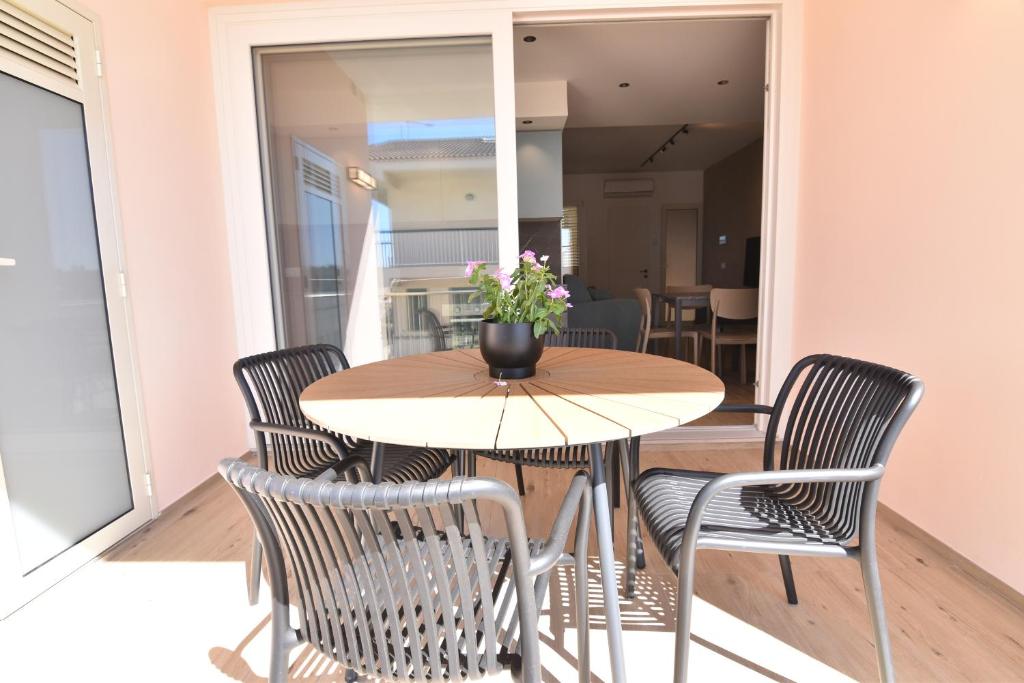 ein Tisch und Stühle mit einer Blumenvase drauf in der Unterkunft Ti porto al mare in Marina di Ragusa