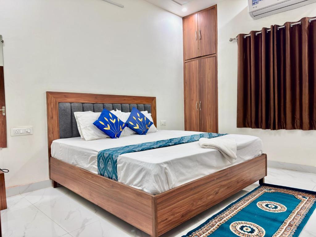 a bedroom with a bed with blue and white pillows at Shree Hanumat Kripa Dham in Vrindāvan
