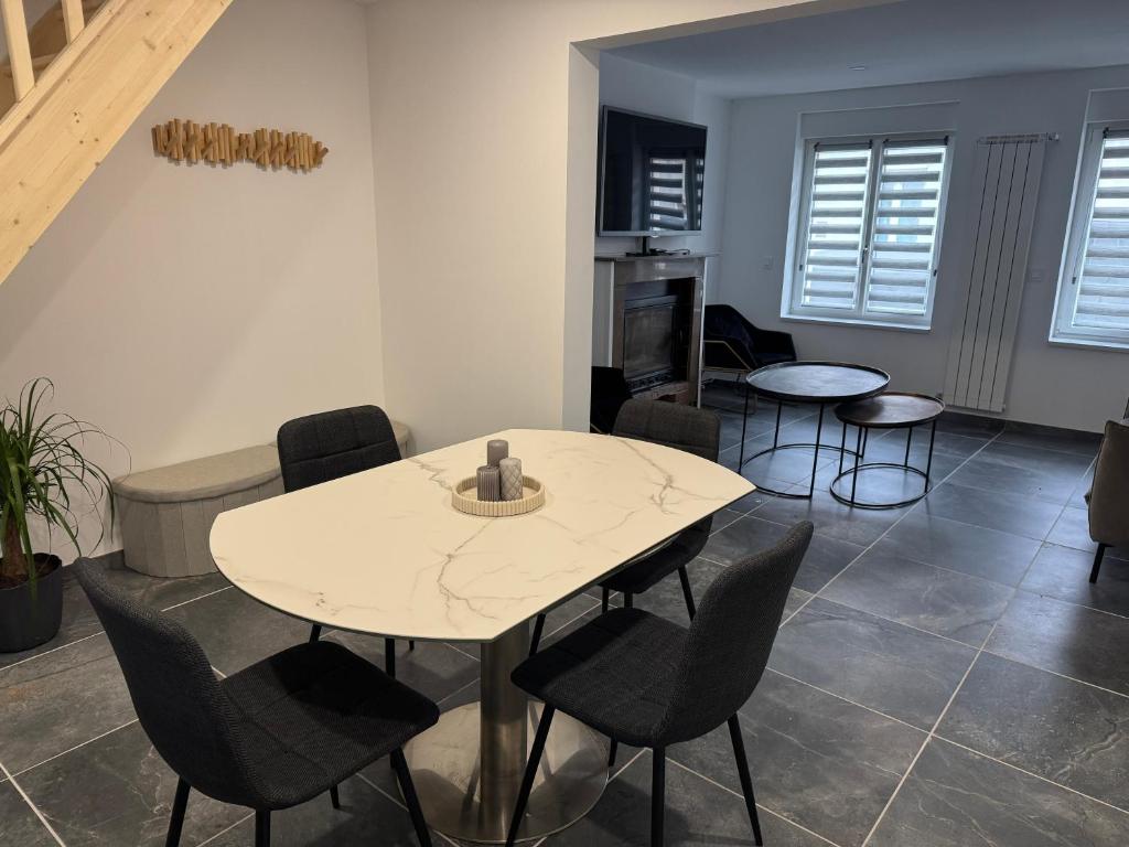 una sala da pranzo con tavolo e sedie bianchi di L'R du Phare maison à 150 mètres de la plage a Gravelines