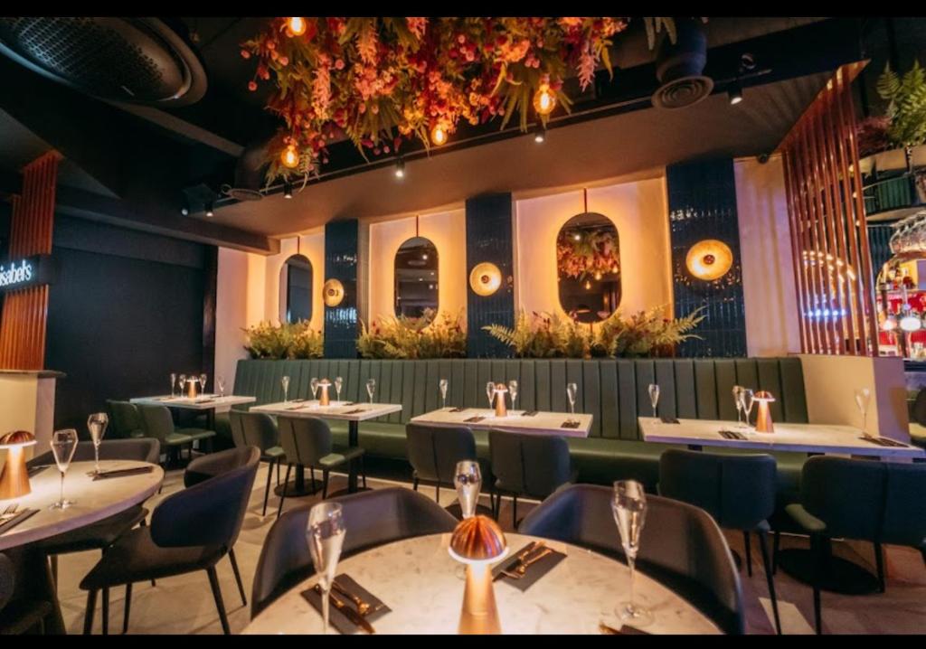 um restaurante com mesas e cadeiras em uma sala em Burton Urban Apartment em Burton upon Trent