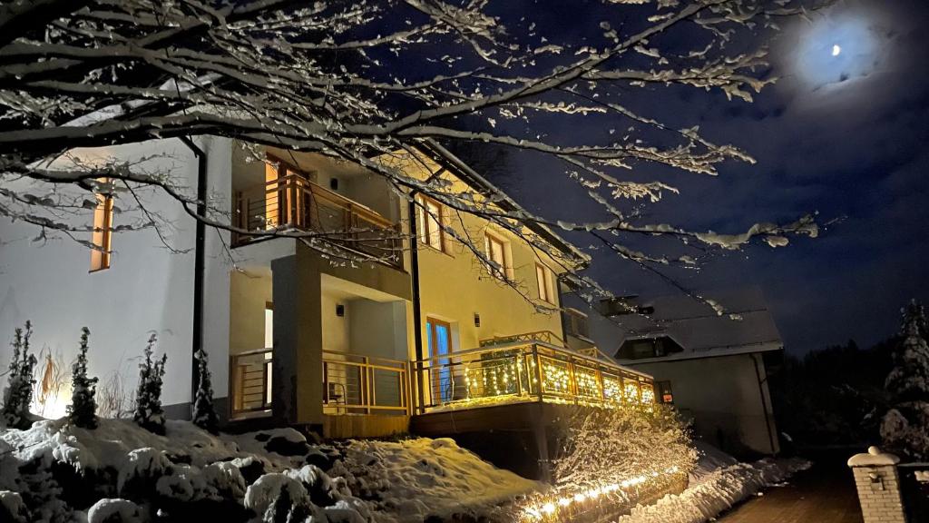 a building with christmas lights on it at night at Dwupoziomowe Apartamenty Leszczyna in Ustroń