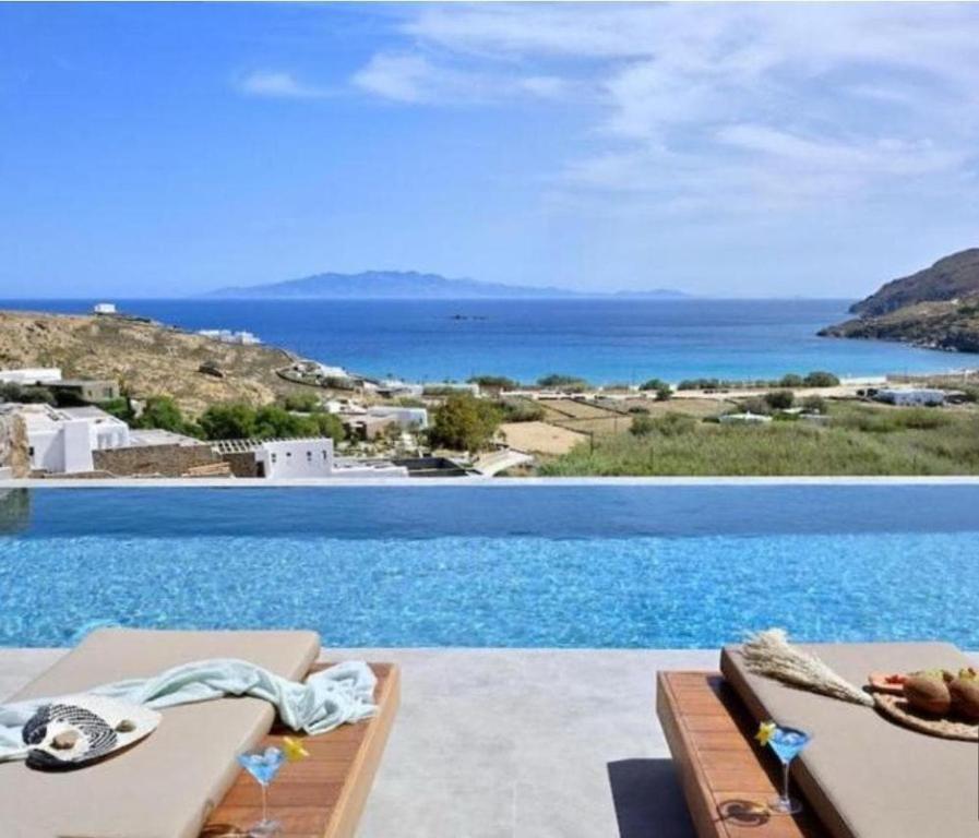 a large swimming pool with a view of the ocean at Villa Altheon Mykonos in Mykonos