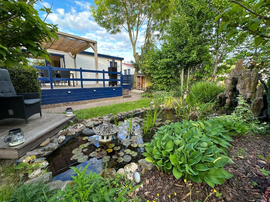 un jardín con un estanque en el patio en Cozy escape near Den Bosch - 4 PS chalet met veel privacy en rust!, en Lith