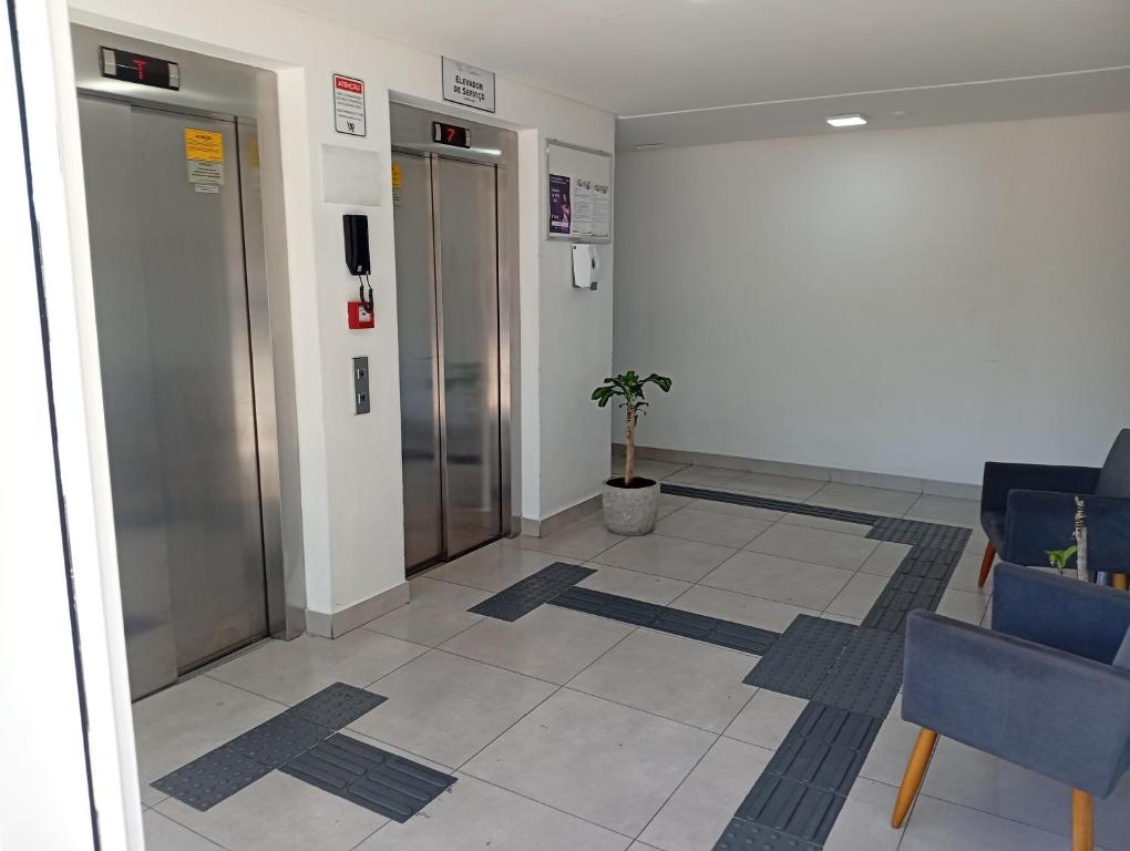 um corredor de aeroporto com elevadores e cadeiras e um saguão em Apartamento dentro da ucs universidade em Caxias do Sul