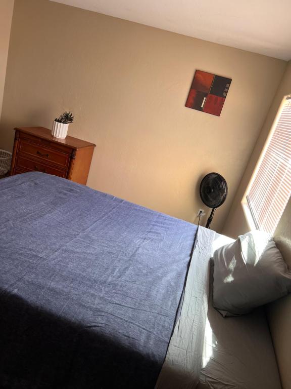 a bedroom with a blue bed and a window at West Valley Spacious Room 2 94th in Phoenix