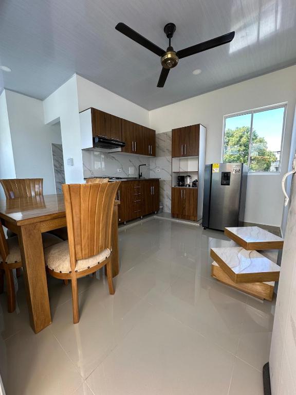 a kitchen with a wooden table and a refrigerator at Fantastico Apto 2 Hab con Parqueo in Montería