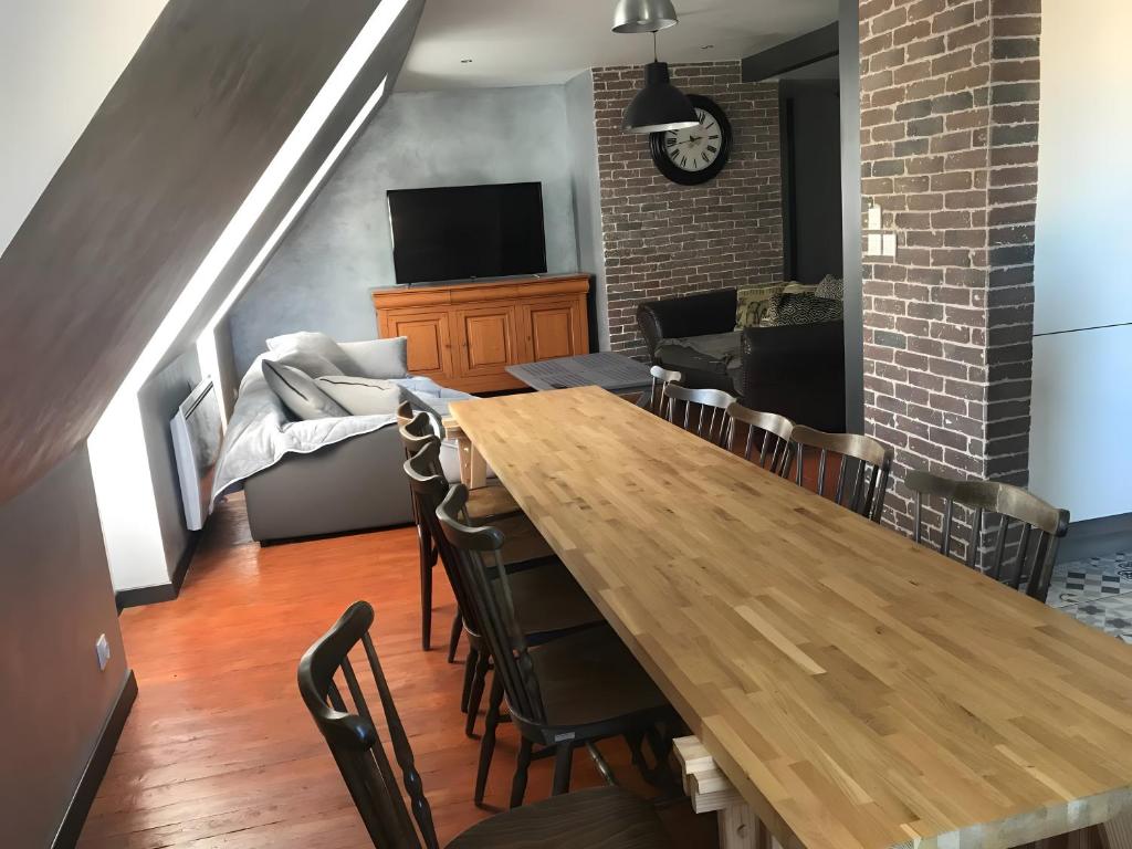 a dining room with a wooden table and chairs at Appartement duplex 180m² in La Bourboule