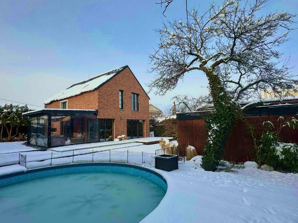 una casa y una piscina en la nieve en VILLA KATARINA with jacuzzi, en Liptovský Mikuláš