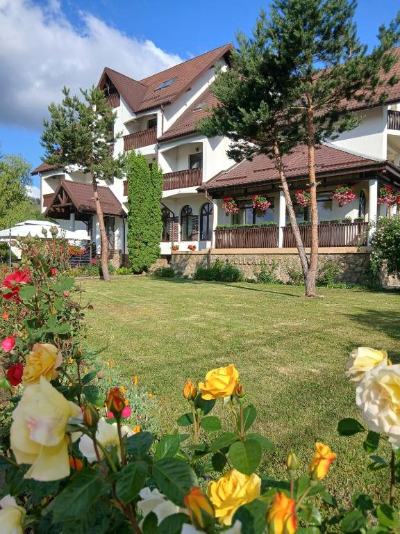a house with flowers in front of it at Pension Elegance in Gura Humorului
