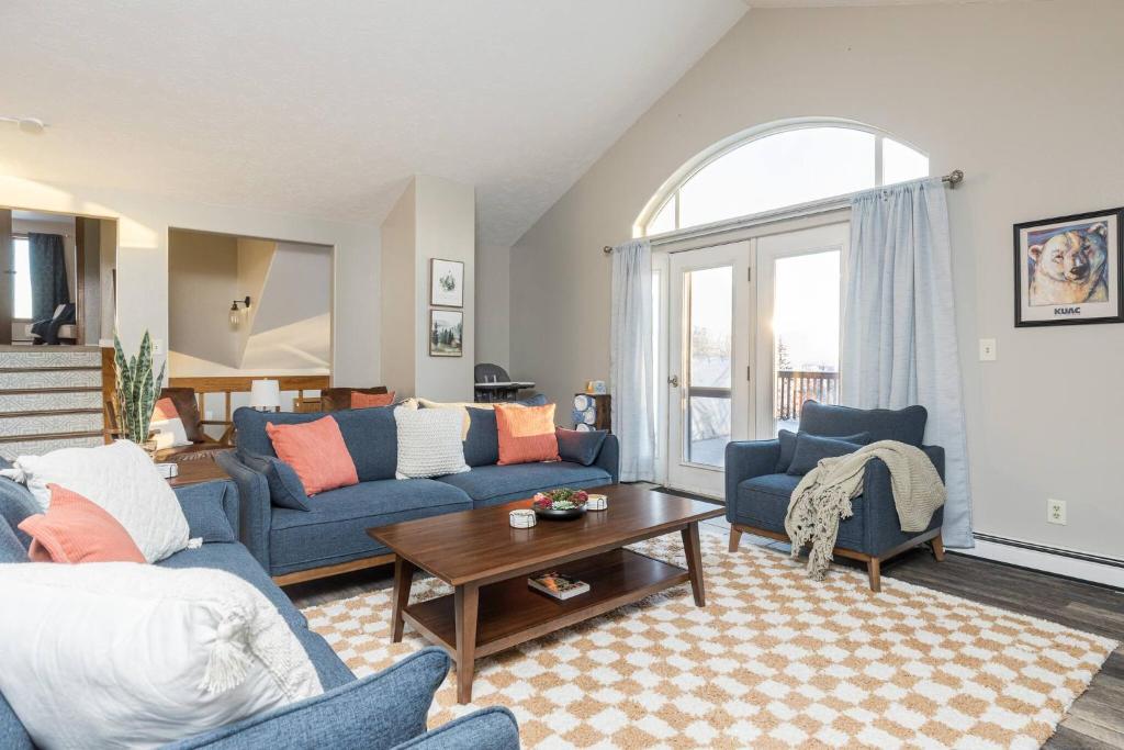 a living room with two blue couches and a table at Group Escape: 6BR Hot Tub, Sauna, Game Rm & Garage in Lemeta