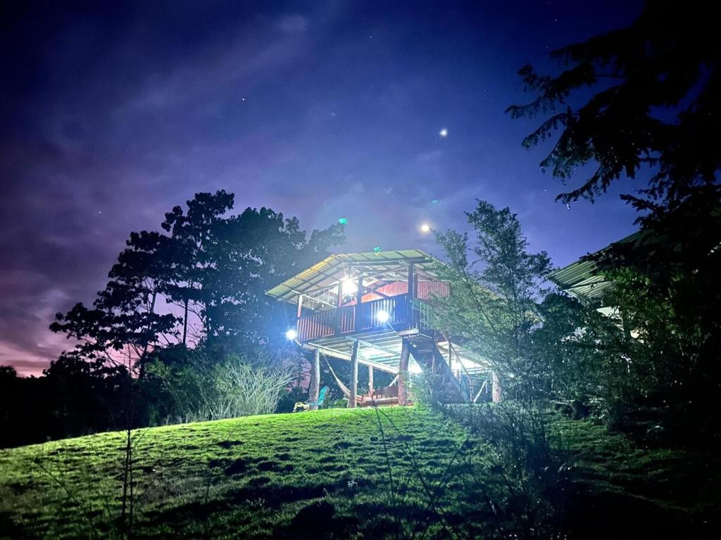 a tree house on top of a hill at night at Rancho Alto Túcan in Buenos Aires