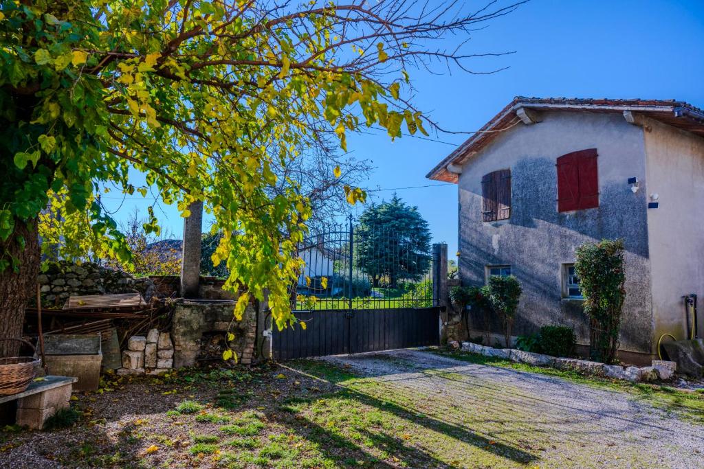 a house with a gate and a tree at Dimora del 700' in Premariacco