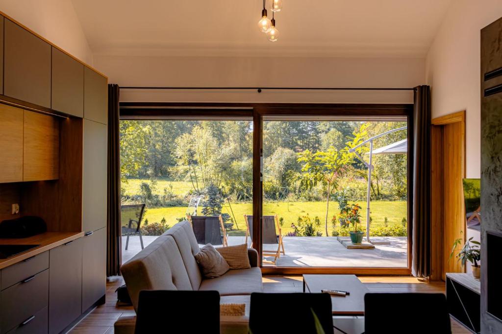 Domki nad potokiem في Lipnica Murowana: غرفة معيشة مع أريكة ونافذة كبيرة