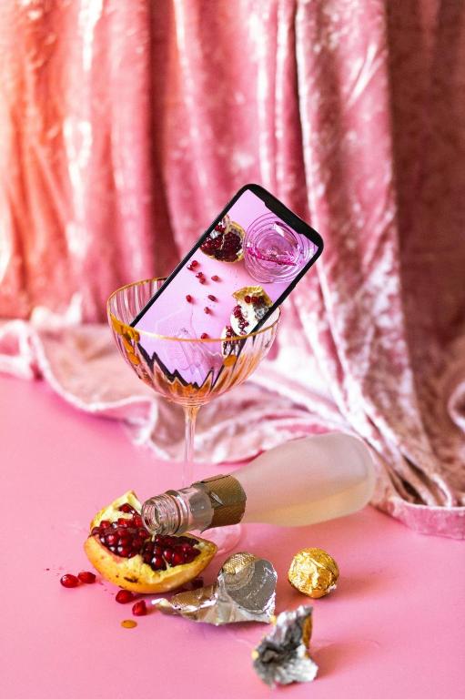 a cell phone in a wine glass on a table at Disney Slumber Party Blloku in Tirana