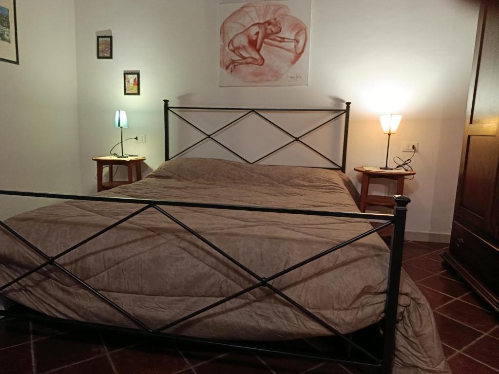 a bedroom with a large bed with two lamps at Podere Casalpiano Alloggio Estivo VENTURINA TERME BARATTI POPULONIA Bella Tuscany in Casa Banditelle