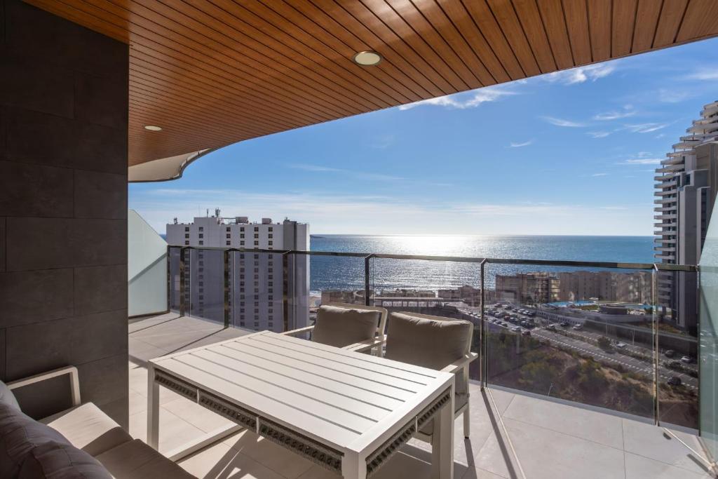 a balcony with a table and chairs and the ocean at Sanset Waves with a sea view! in Benidorm