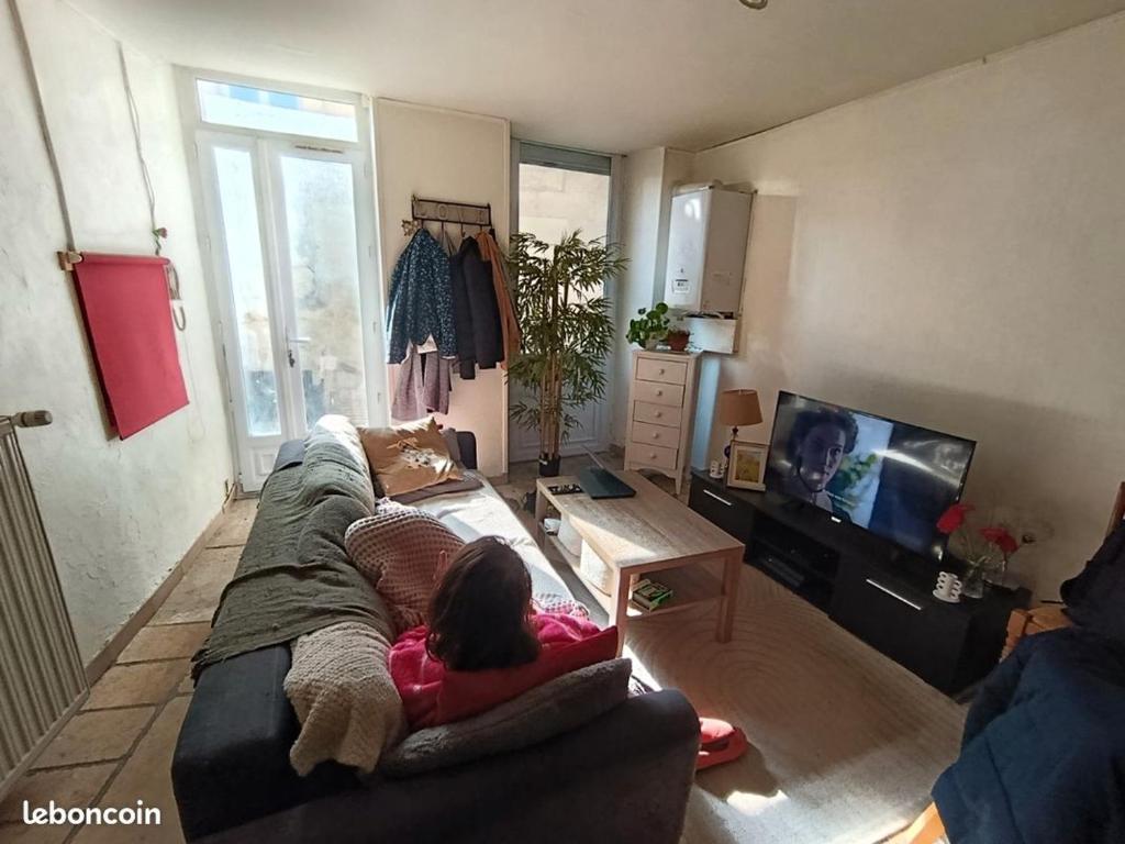 a little girl laying on a couch in a living room at Studio Confort Niort in Niort