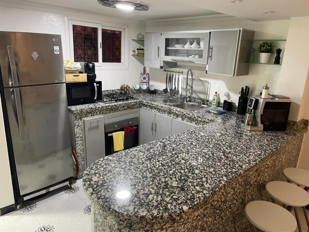 a kitchen with a black and white counter top at Ryad Lalla khadija in Marrakech