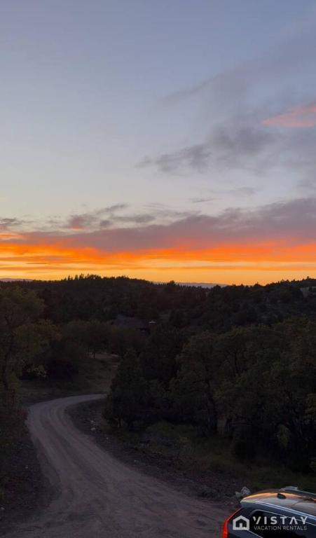 a car driving down a dirt road at sunset at The Wandering Doe Readers Retreat with Hot Tub in Long Valley Junction