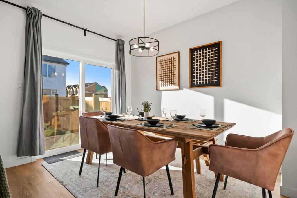 Luxe Retreat with Gym, Ping Pong, King Bed, Near WEM في إيدمونتون: غرفة طعام مع طاولة وكراسي خشبية