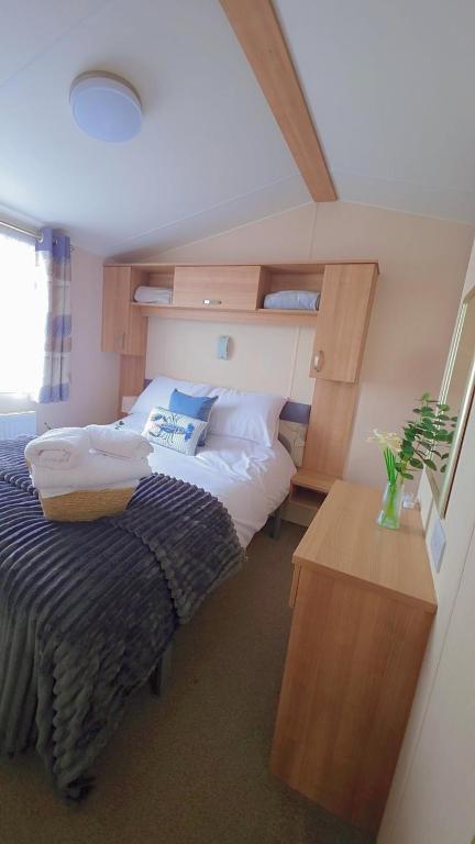 a bedroom with two beds and a wooden table at 17 Ruby Atlas Monreith in Monreith