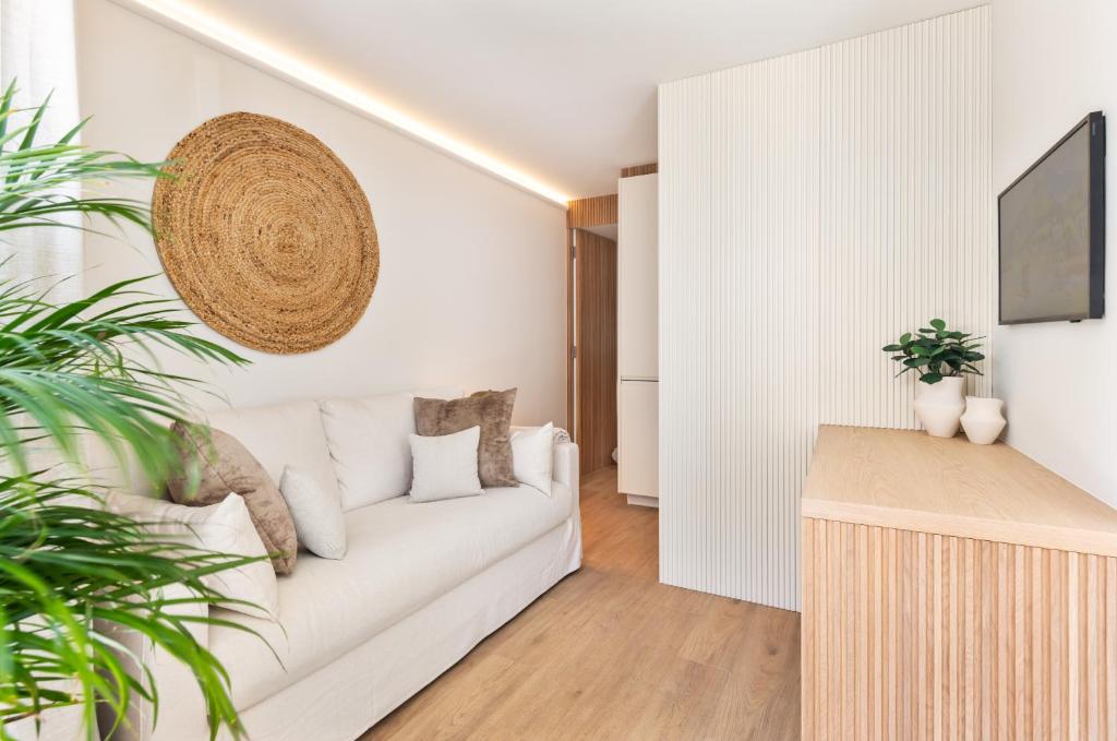 Sala de estar blanca con sofá blanco en BLQ Charneco 1BDR in Boliqueime by LovelyStay, en Boliqueime
